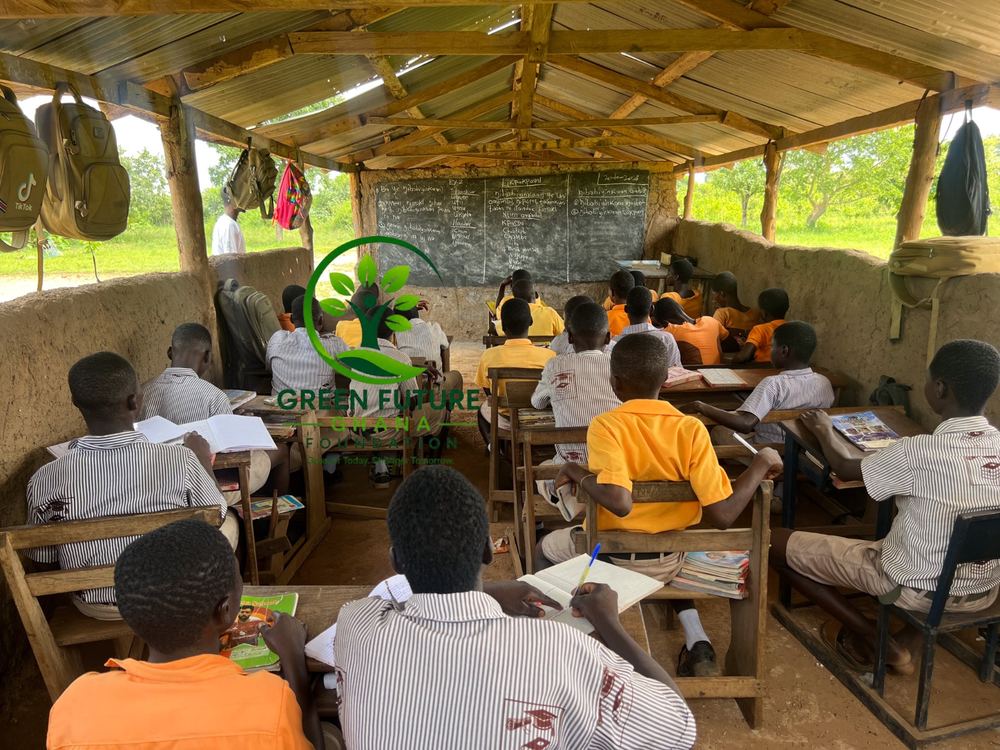 Pupils at their desks in a classroom with a wooden roof