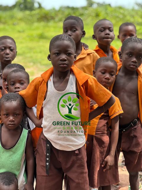A group of children in orange uniforms looking at the camera